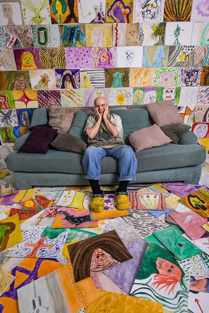 A picture of a man surrounded by paintings