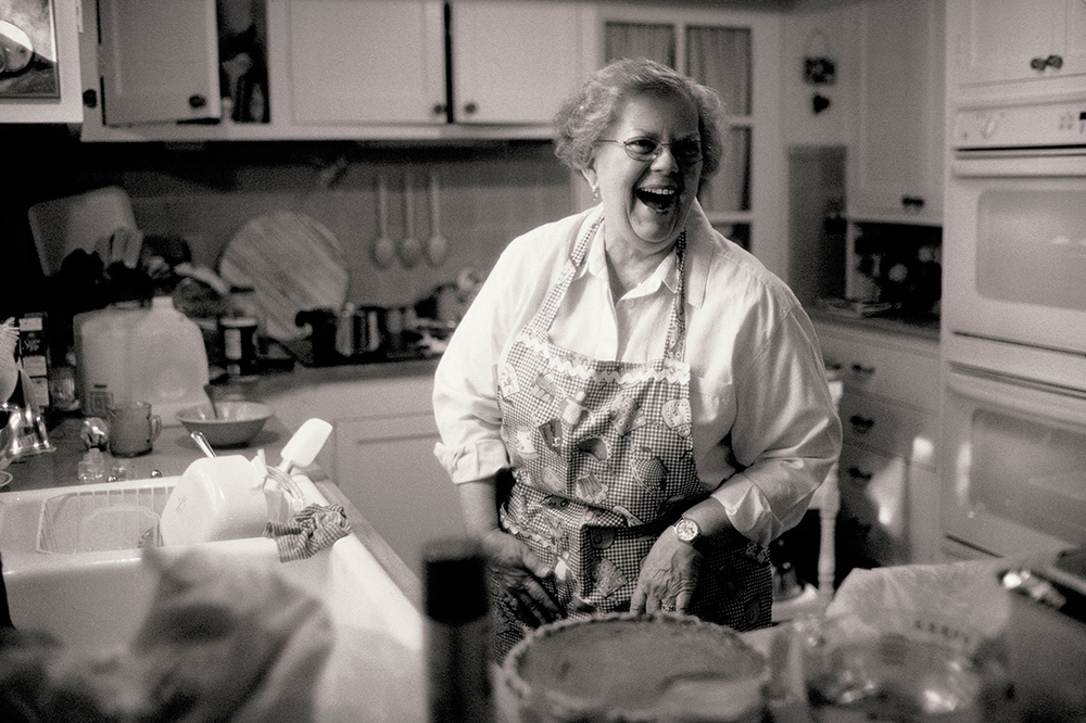 woman laughing in her kitchen