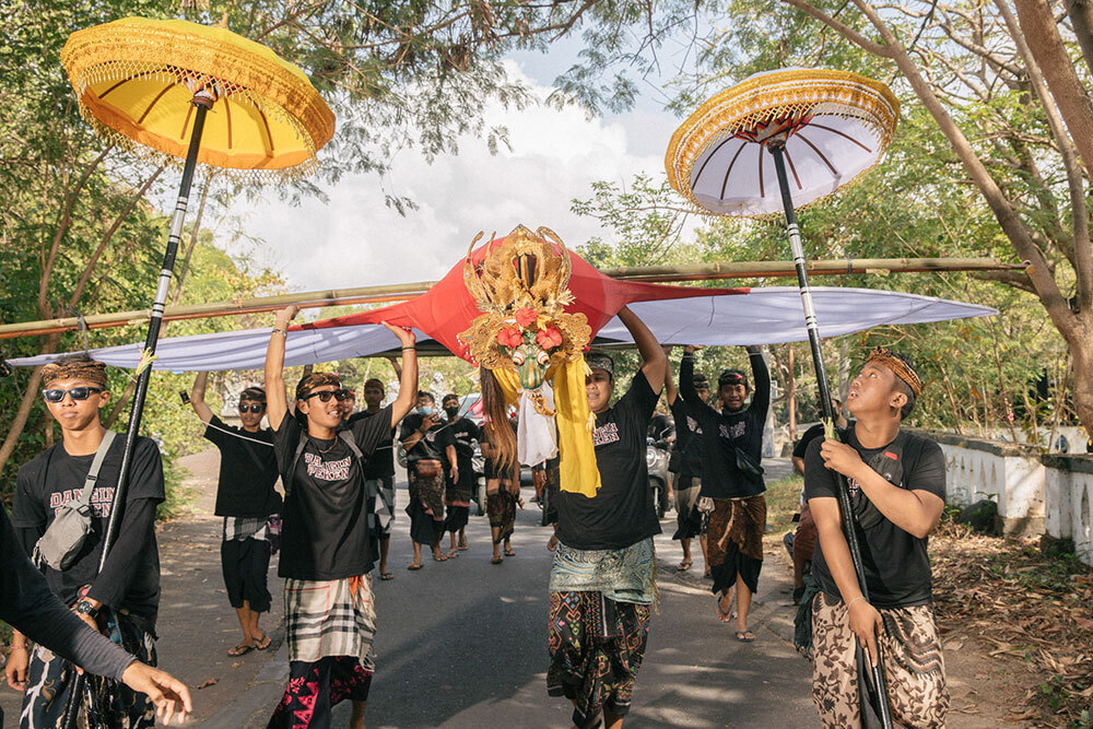 People carry a large kite during a festival in Bali