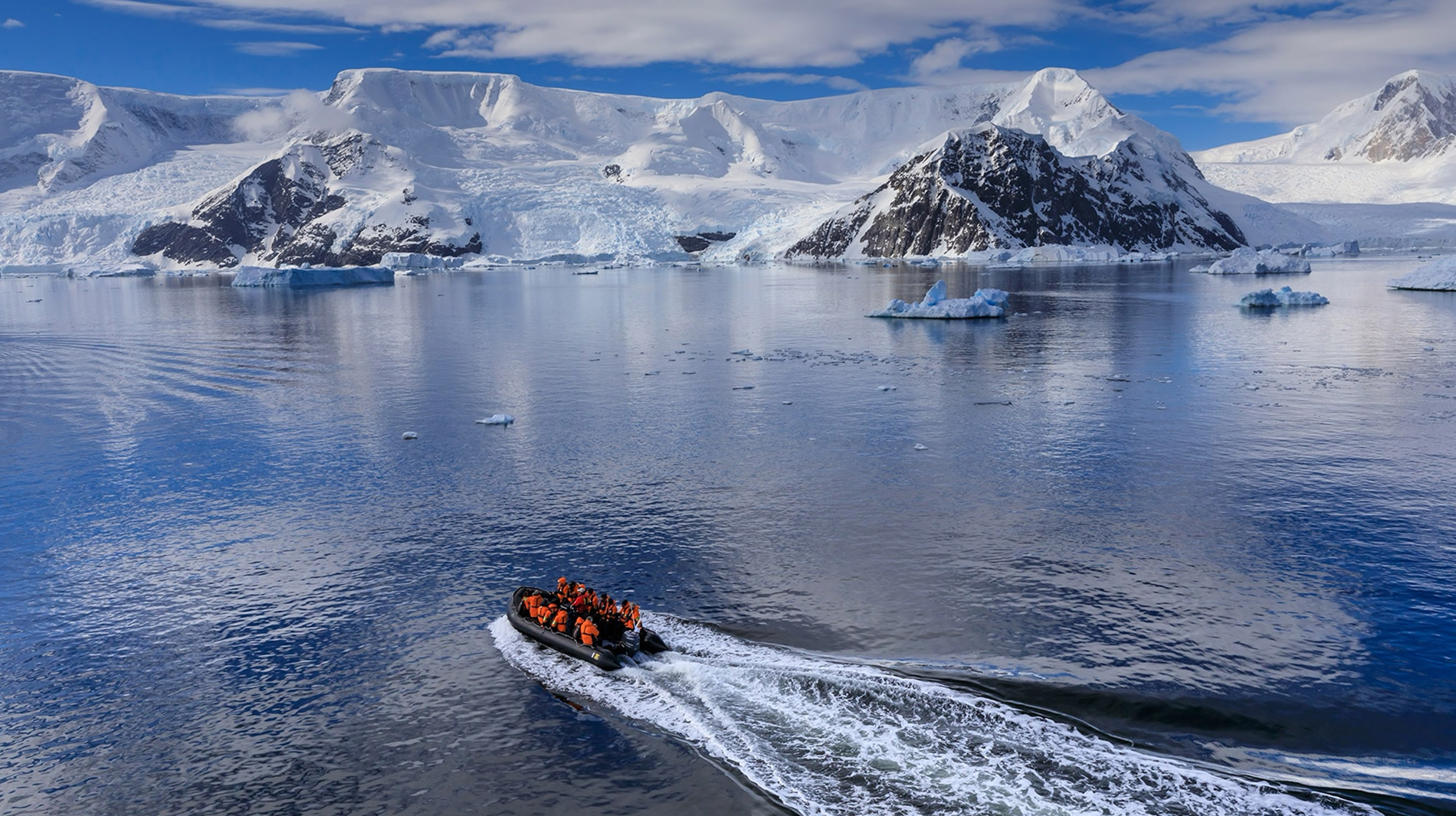 A Zodiac speeds ecotourists across Andvord Bay, Antarctica, where they get a glimpse of what it’s like to be a scientist studying this fragile region.