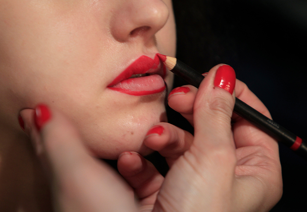 A model has red lipstick applied