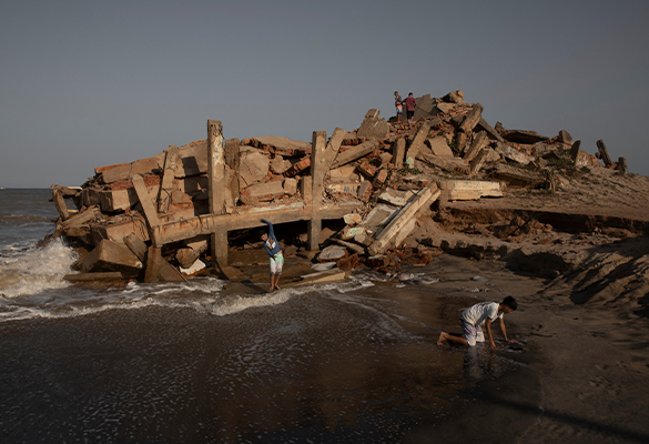 Atafona residents play in the ruins of the town, which has lost 14 blocks to rising seas and eroding sands. At low tide, buildings that were taken by the sea decades ago emerge from the sand.