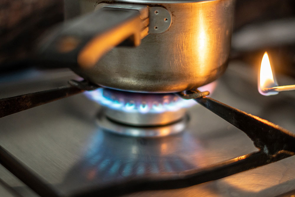 A pot heating above a flame on a gas stove