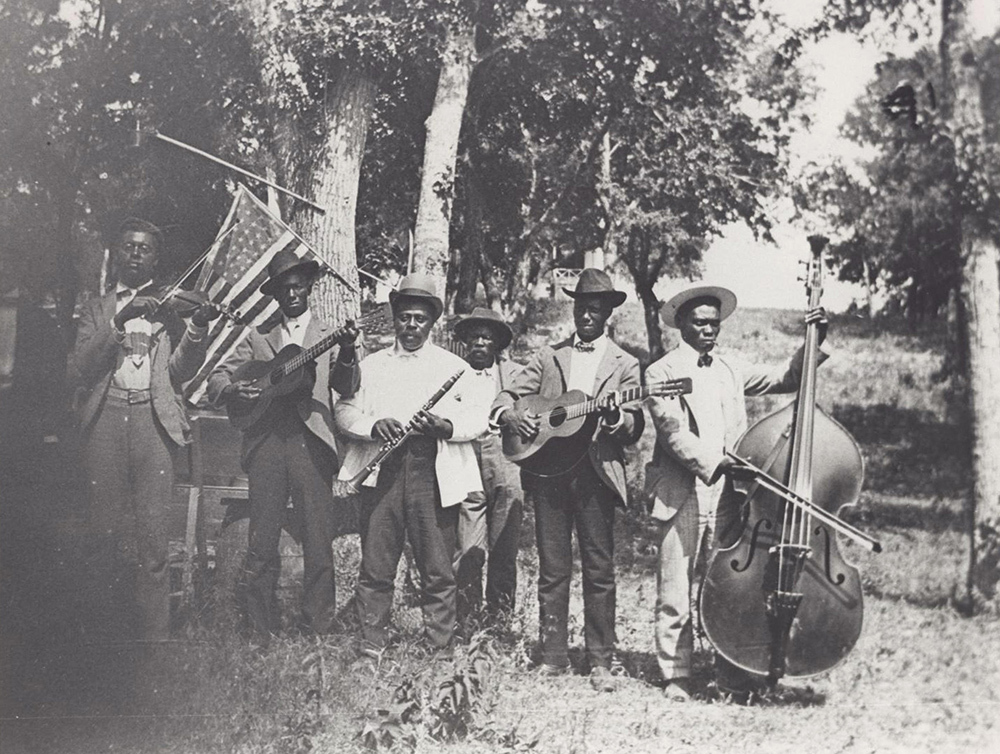 Musicians at 1900 Juneteenth celebration in Austin, Texas, pose before the U.S. flag