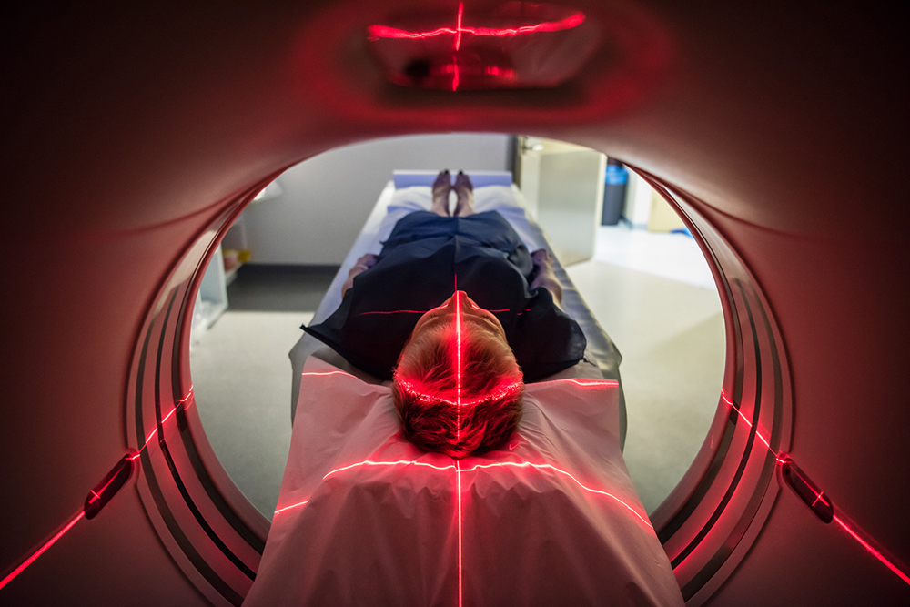 A view inside a CT scanner as a patient is positioned using red projected lines of light