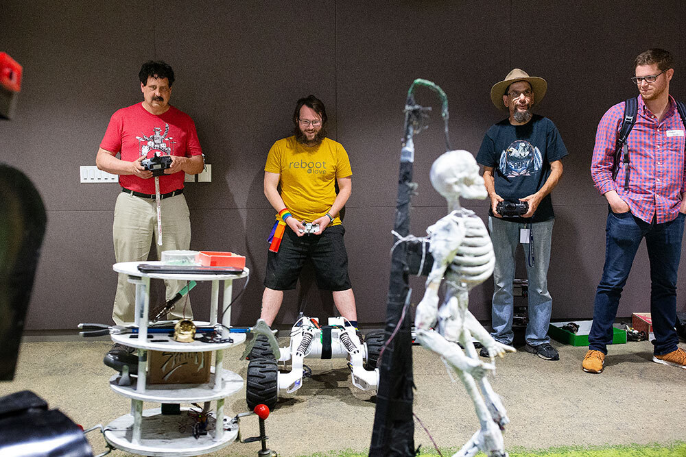 A picture of a row of men with remotes and robots