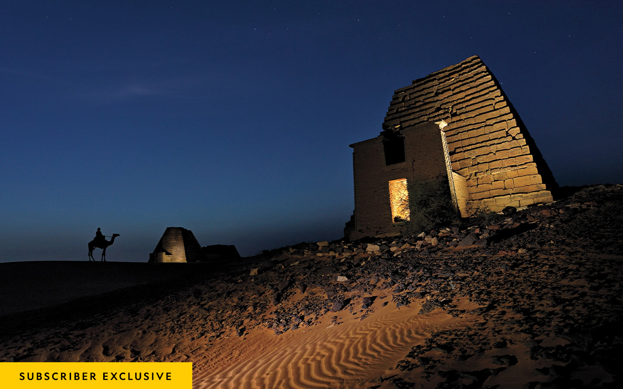 A rider on camelback surveys the steep-sided pyramids of Mero in Sudan.