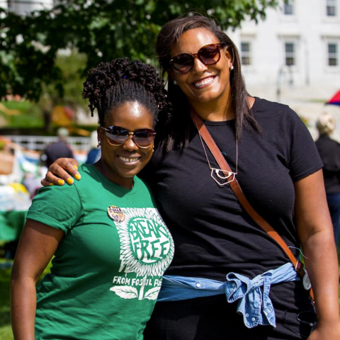 Two advocates smiling at a climate justice event.