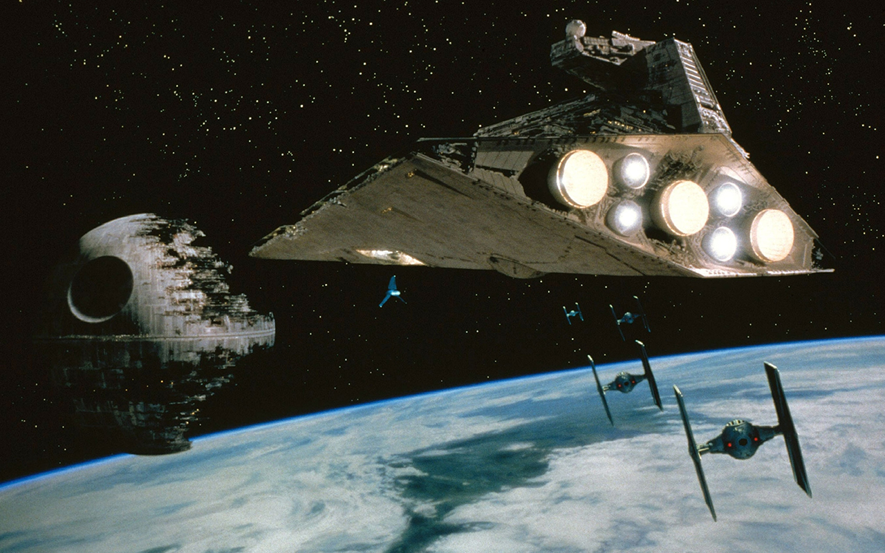 A scene from Star Wars where a Star Destroyer approaches the Death Star.