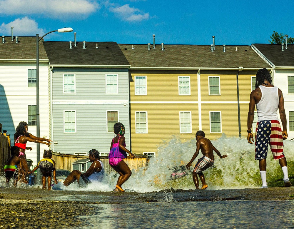 On a 90 degree day in Southeast, Washington D.C., community members cooled off as they enjoyed playing in the water hydrant, which is a tradition summertime activity.