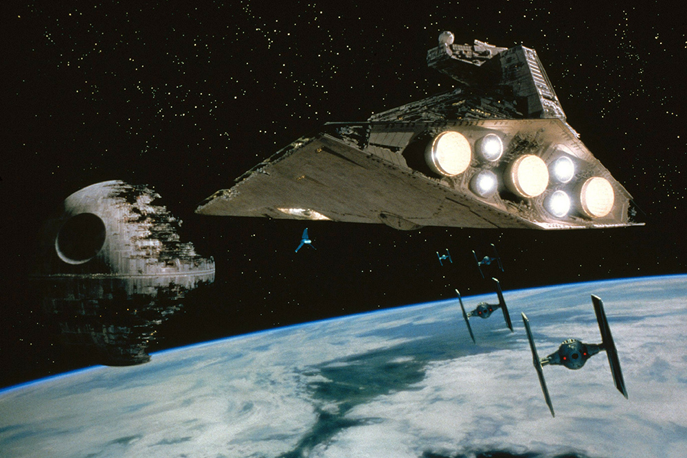 A scene from Star Wars where a Star Destroyer approaches the Death Star