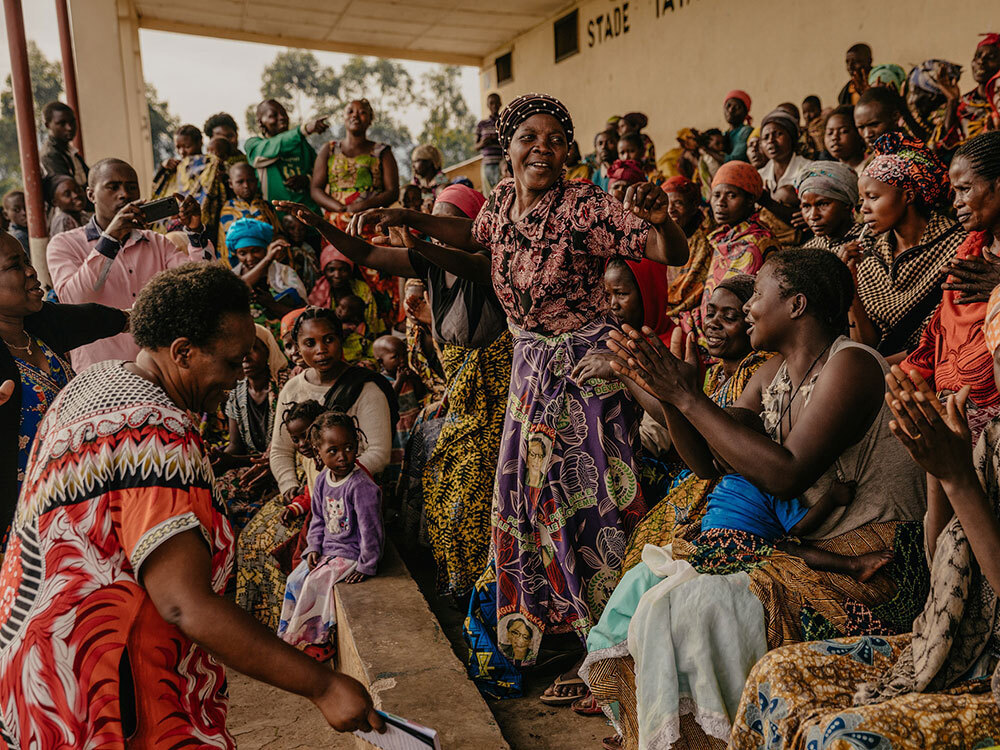 One women stands and speaks in a crowd of other women