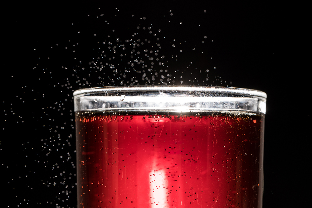 A close up view of a red, fizzy soda.