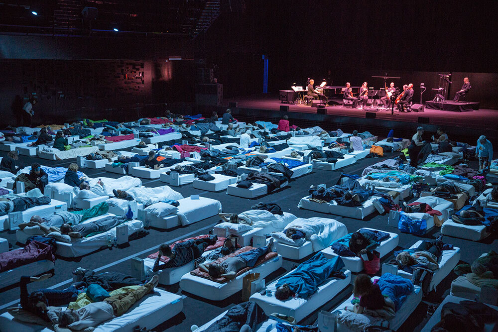 people sleep while an orchestra plays