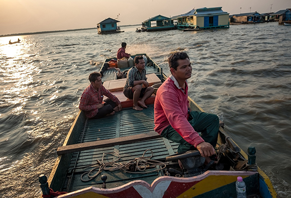 A fishermen drives past a floating village on Tonle Sap. Many residents that live on the lake are experiencing drought and diminishing water levels, and are abandoning fishing for farming in the increasingly dry swamp forest around the lake.