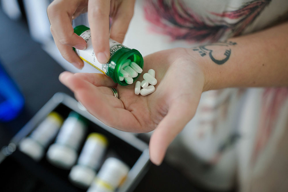 A picture of a a person pouring pills from a bottle into their hand