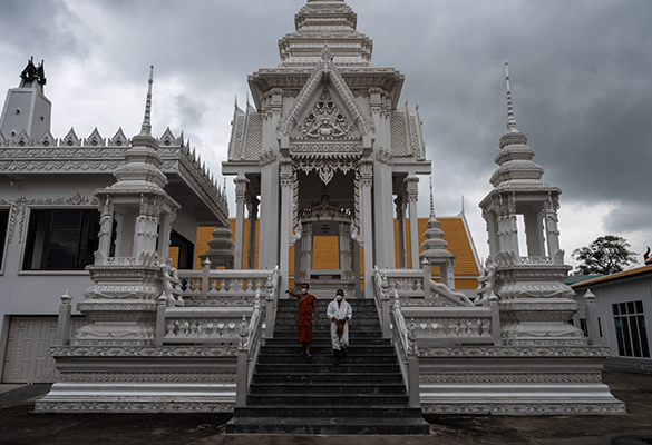 Buddhist monks walk down the stairs of a temple that provides free cremation services for COVID-19 victims in the Pathum Thani province of Thailand.