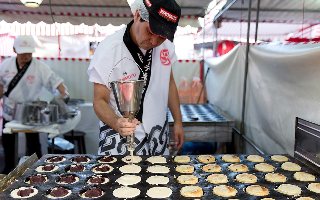 A street vendor prepares dorayaki, a mini-pancake filled with sweet bean paste.