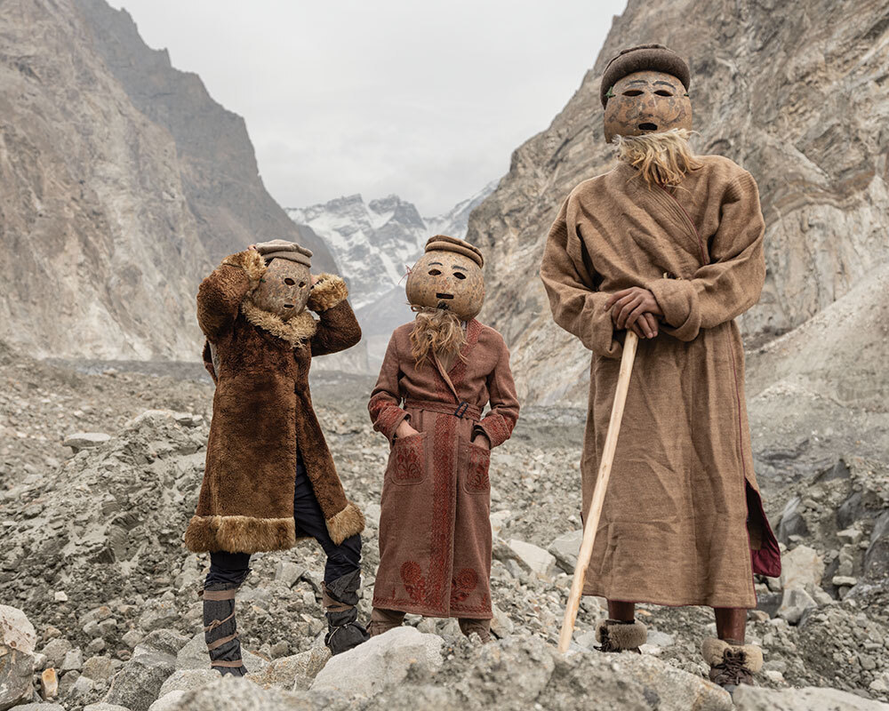 A photo of three people wearing masks in a mountain valley