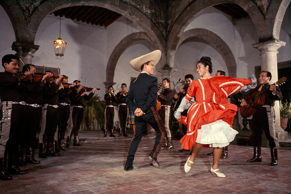 A man and a woman in Mexican dress dance