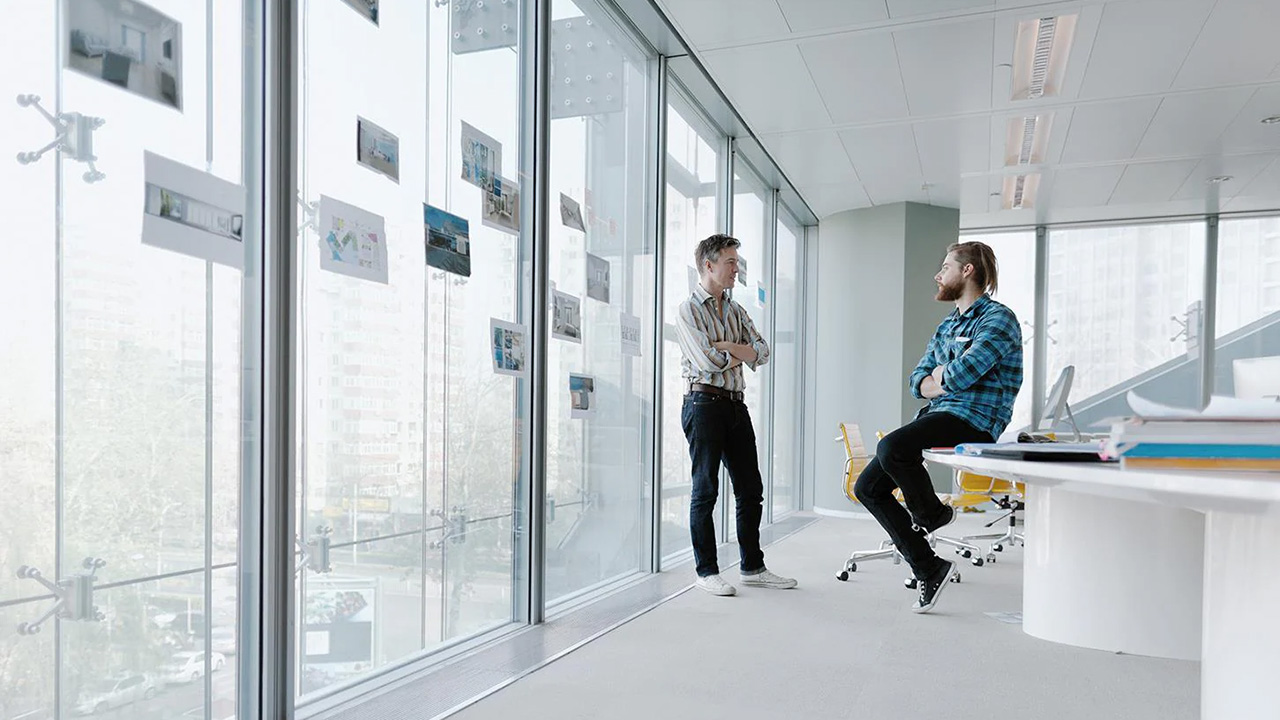 Two people talking to each other in an office.