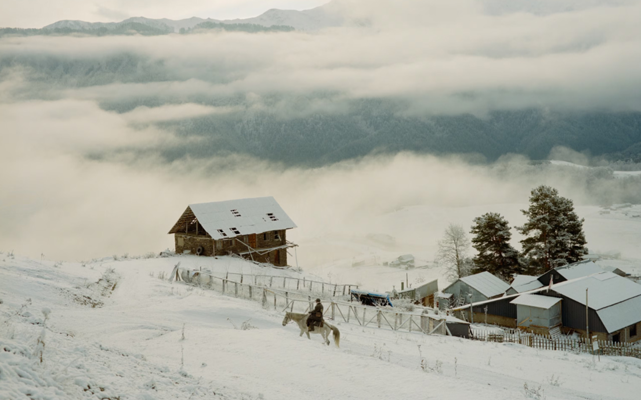 Irakli Khvedaguridze, 80, is the only licensed doctor across nearly 386 square miles of mountainous land in the Tusheti region of northeast Georgia. Here he rides his white horse, Bichola, through the village of Omalo. In the background is the clinic where he obtains limited medical supplies.