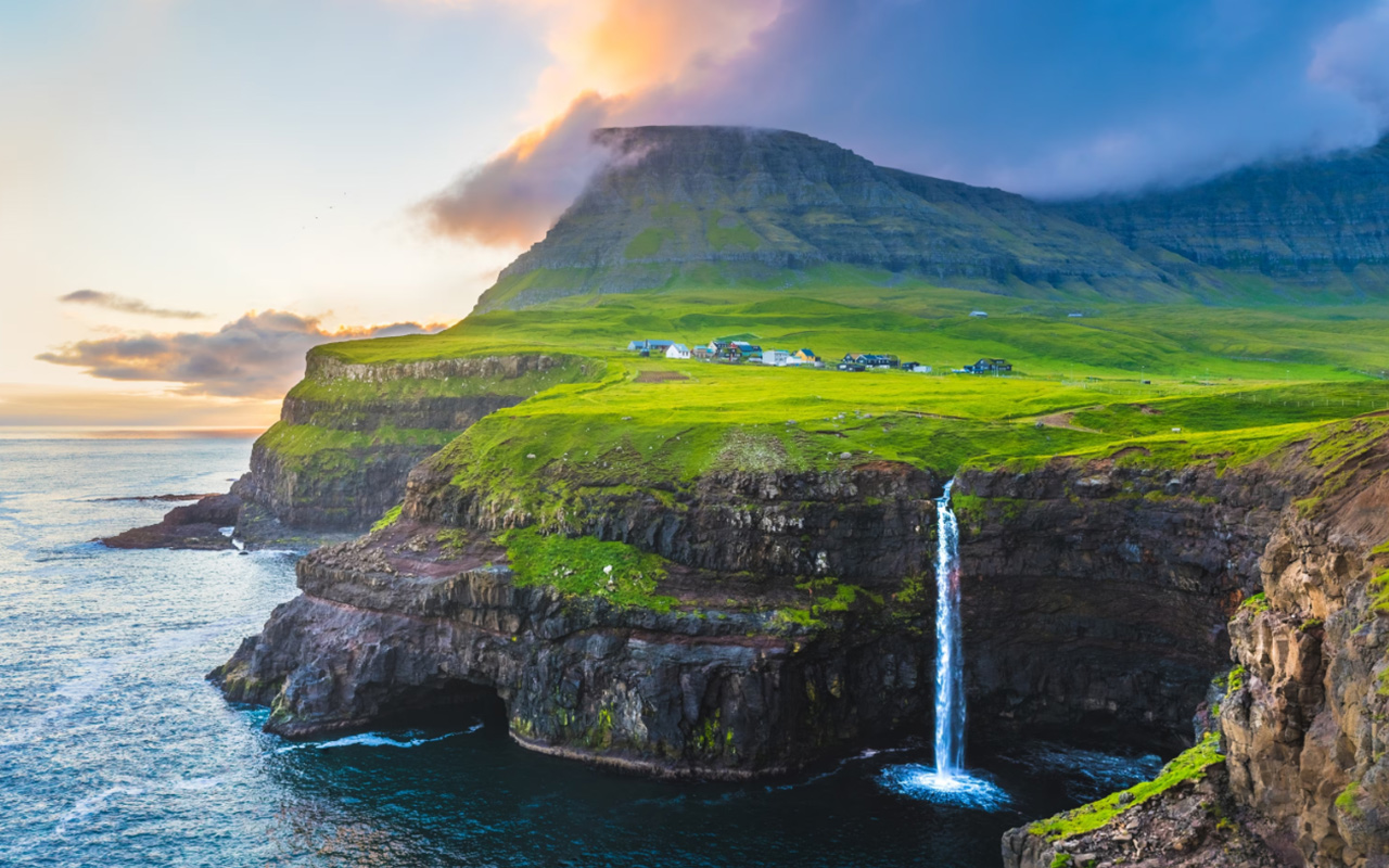 A view of Mulafossur Waterfall along the cliffs of the Faroe Islands.