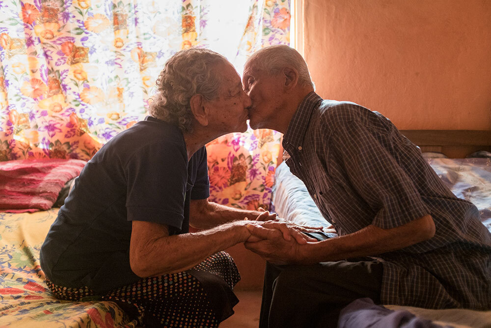 A couple, who have been married for 72 years, holds hands and kiss in Costa Rica, 2017.