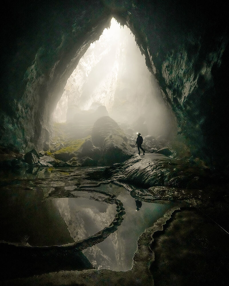 A picture of a person at the mouth of a cave