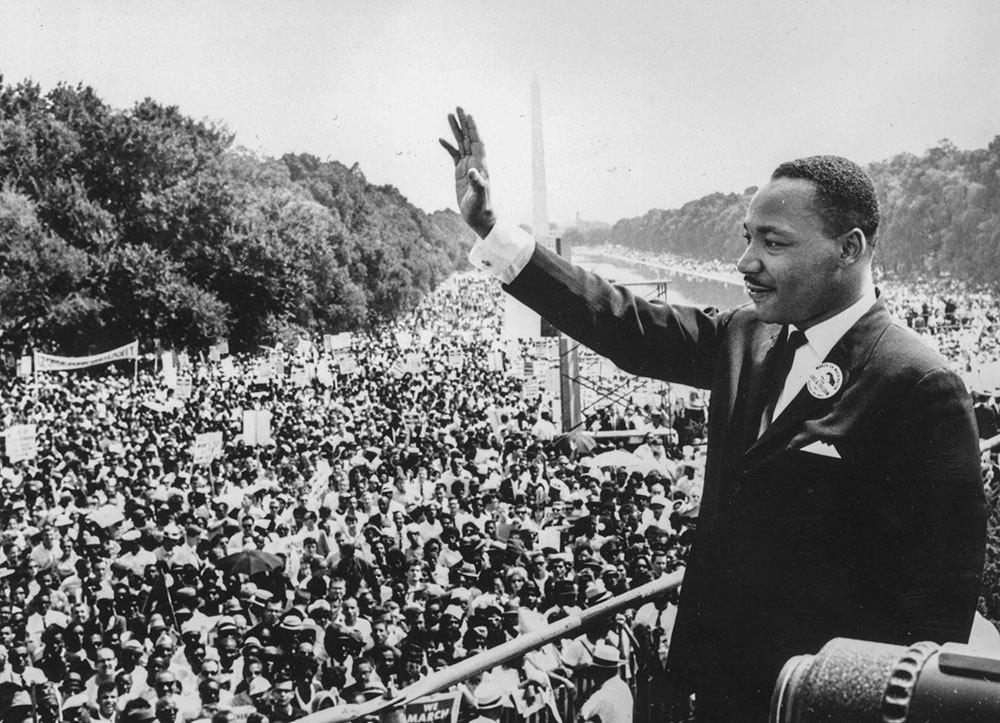 A picture of Marting Luther King Jr. waving near the Lincoln Memorial on the National Mall in Washington, D.C.