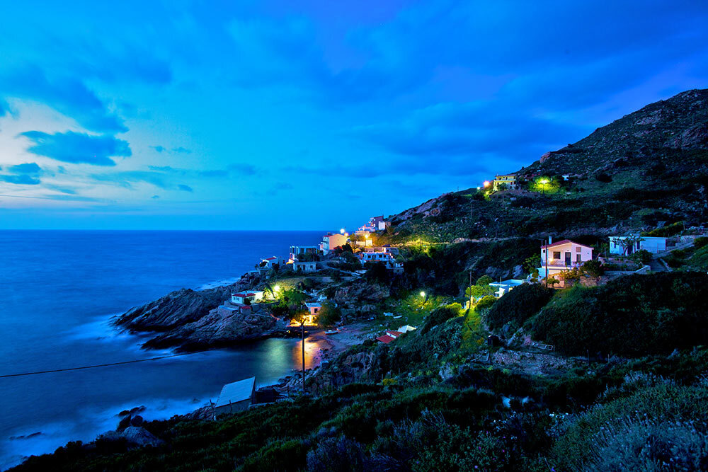 Dusk view of a village on the north shore of Ikaria Island, Greece.