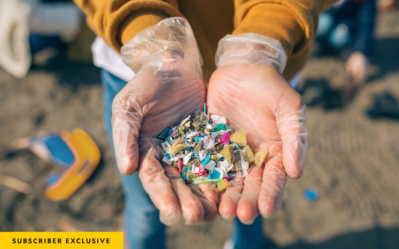 Picture of hands showing microplastics on the beach.