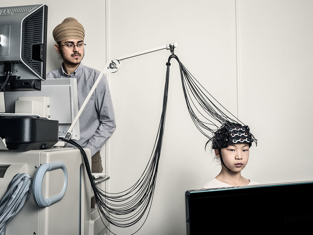 Darshan Panesar and nine-year-old Amelia Tong demonstrate functional near-infrared spectro­s­copy technology