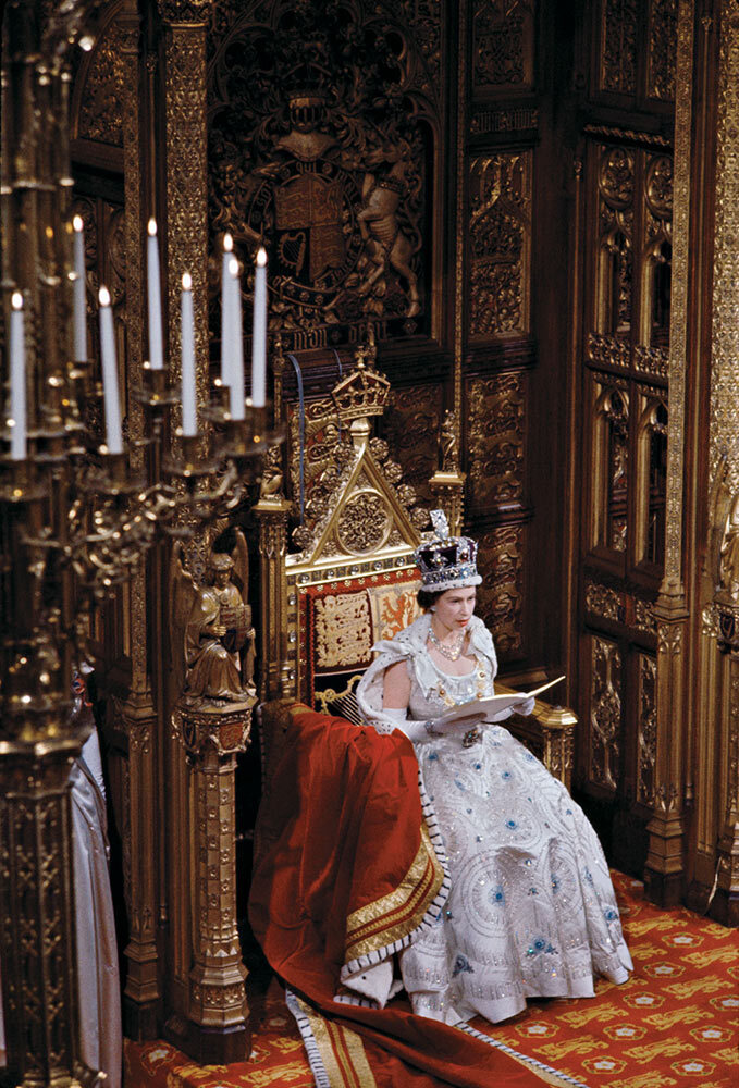 Queen Elizabeth II, seated on a golden throne and wearing the jeweled State Crown, opens Parliament in 1960.