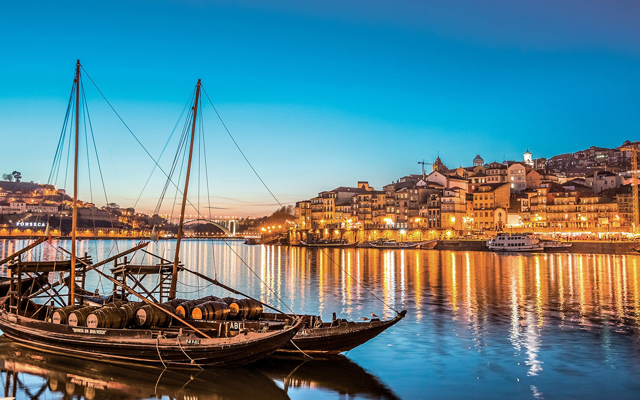 Porto, with its six bridges spanning the Duoro River and endless casks of port wine, dazzles at dusk.