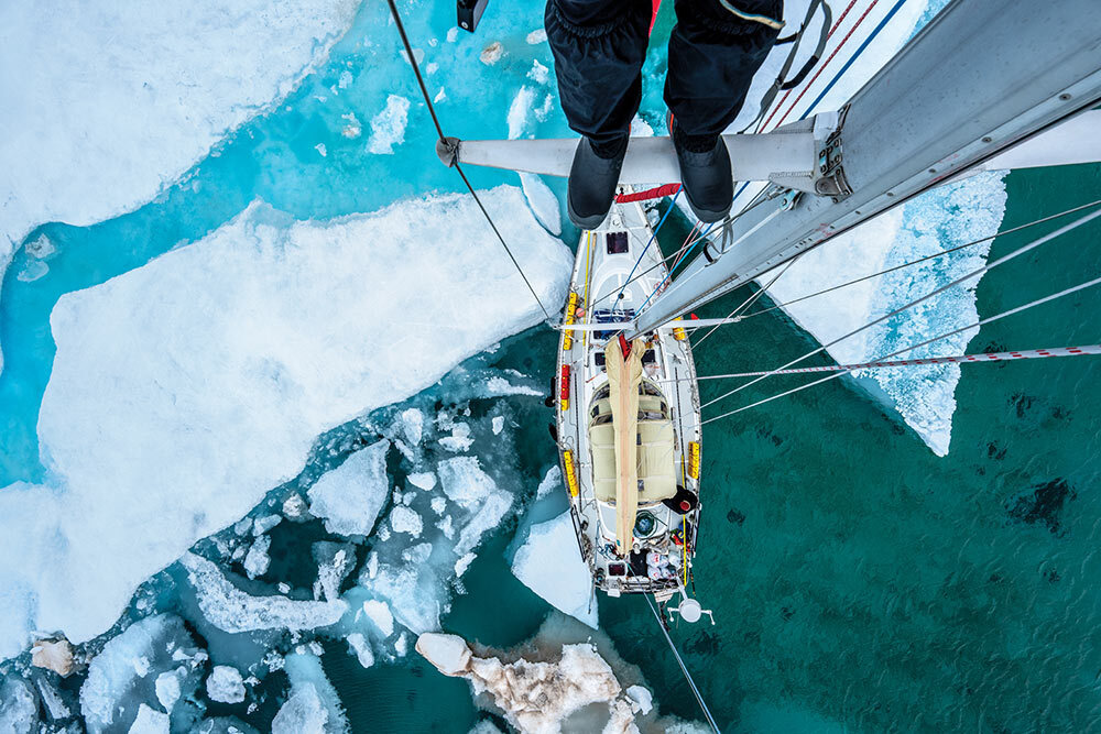 Photographer Renan Ozturk surveys Canada’s Pasley Bay from atop the mast of Polar Sun.