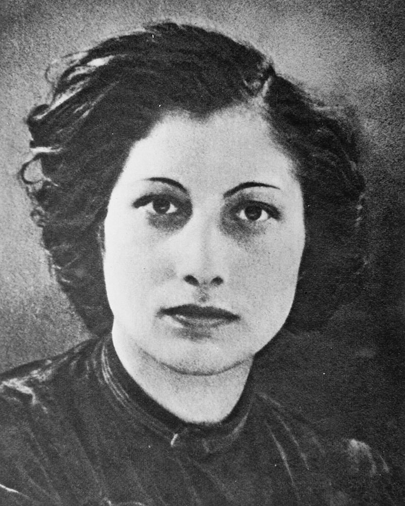 Noor Inayat Khan, her hair is parted and she looks straight into the camera for a portrait that's tightly cropped around her face