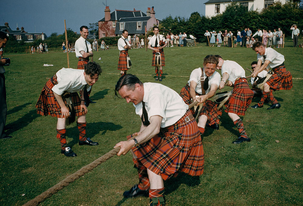 Men in tartan kilts competing in tug of war