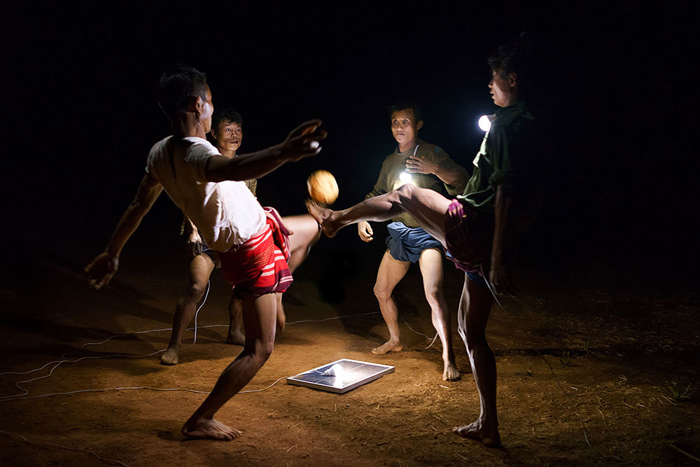 A picture of people kicking a ball by the light of a flashlight