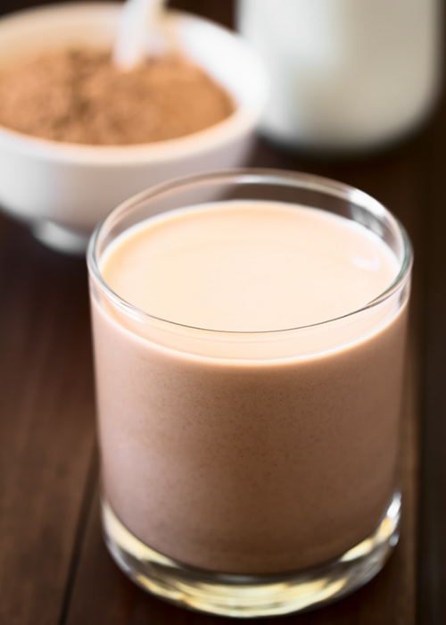 A glass of chocolate milk on a tabletop, showcasing the rich and creamy beverage ready for consumption.