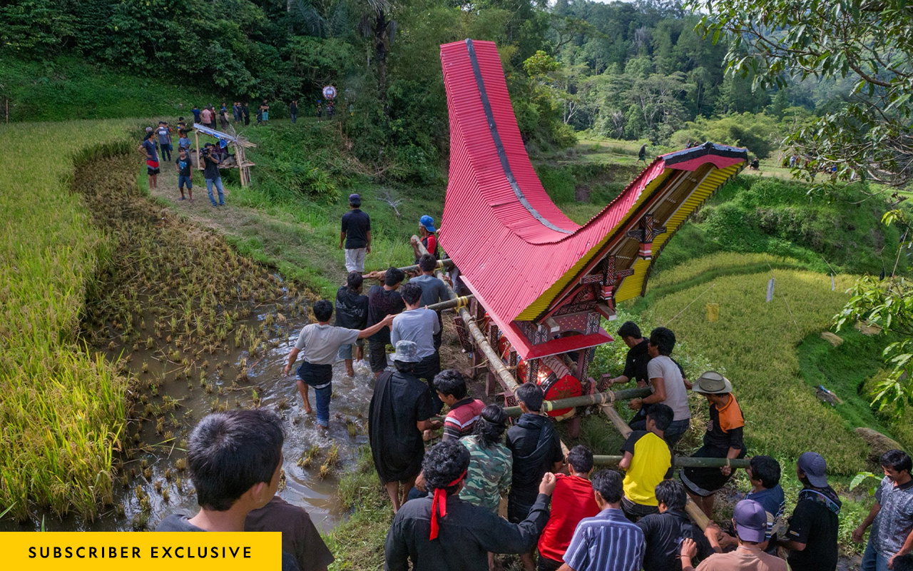 Friends and family carry the body of Abraham Papa to his grave in a wooden duba duba, a funeral bier made to resemble the ancestral family homes, called tongkonan, that dot Toraja