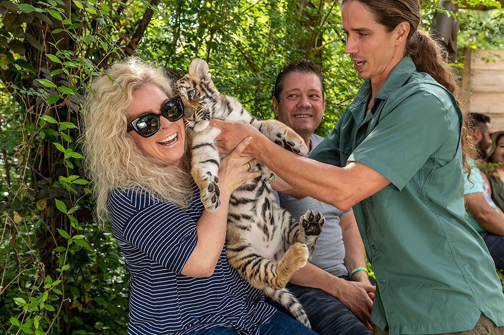A picture of a woman holding a tiger cub