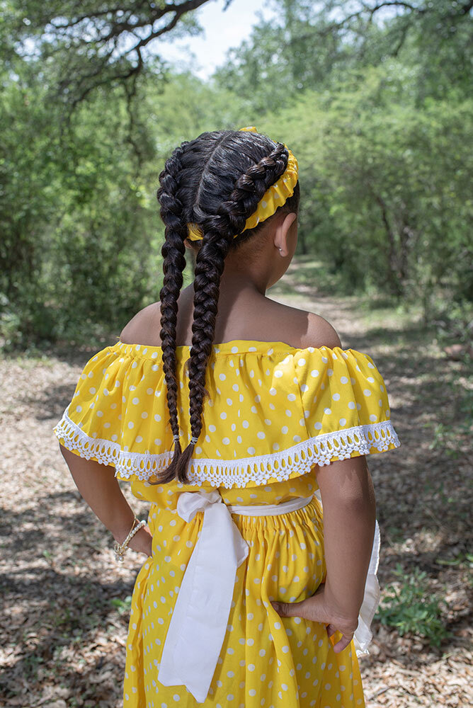 A young girl dons on the traditional attire—polka-dot dress, apron, and handkerchief—worn by Mascogos women during Juneteenth celebrations in Nacimiento