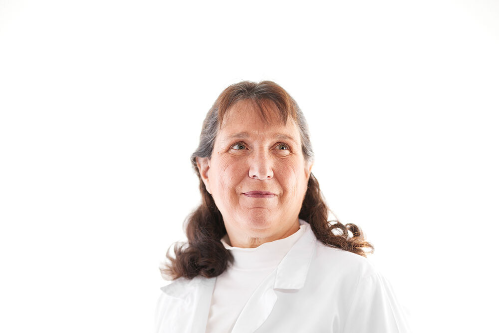 A portrait of a woman in white with a bright white background