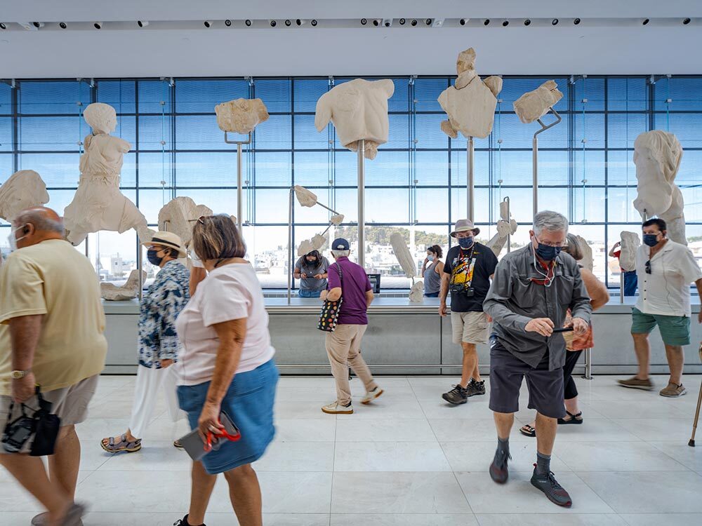 Visitors in front of fragments of the Elgin Marbles at the Acropolis Museum in Greece