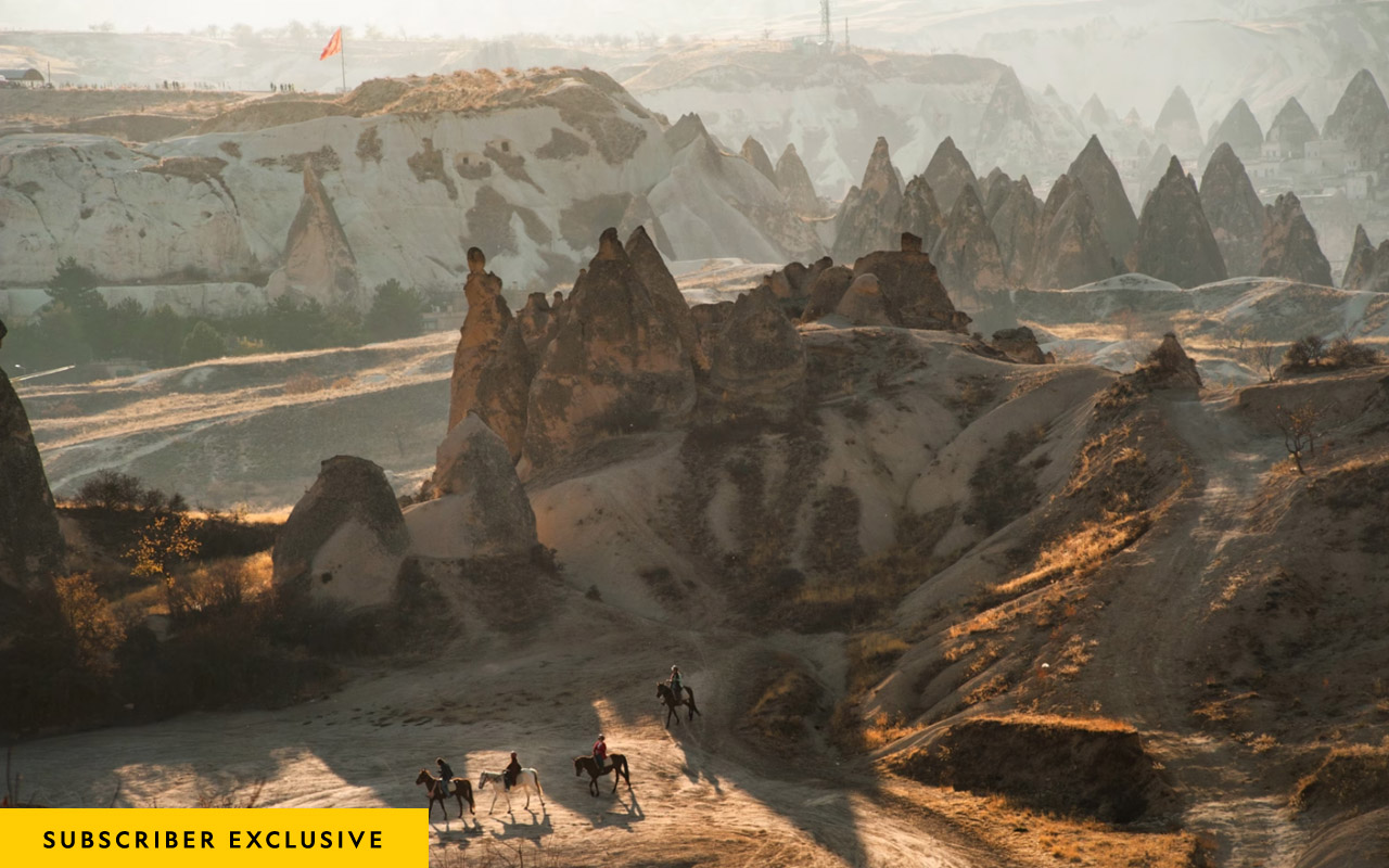 Riders pass through the volcanic landscape in Cappadocia near Goreme, Turkey.