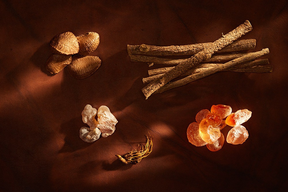 Piles of different types of spices are arranged on a brown cloth