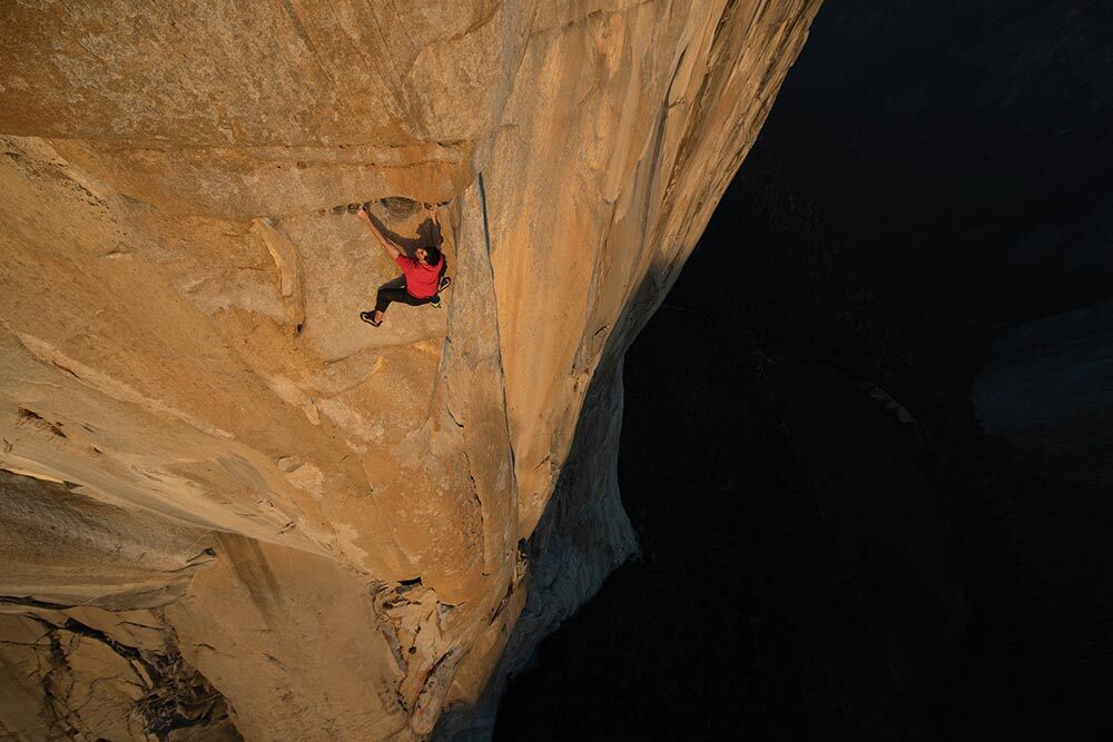 Person on vertical wall high above ground.