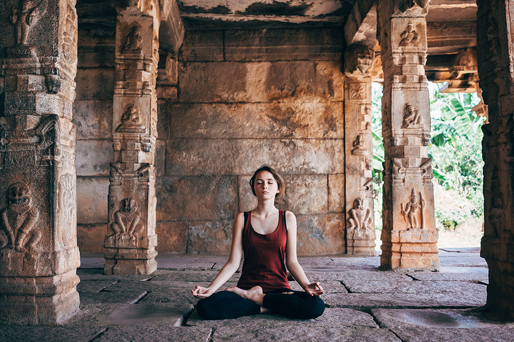 A woman doing yoga with her legs crossed