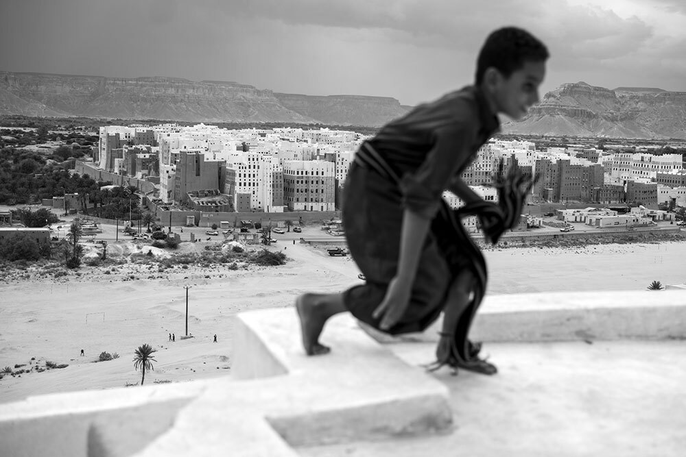 A child plays with the city in the background